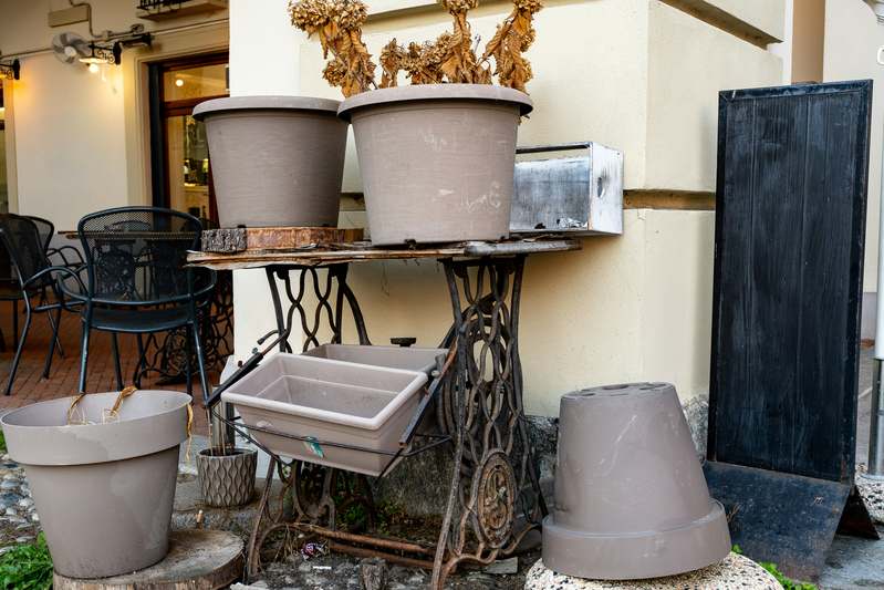 Hands planting flowers into a wooden planter box on a garden table