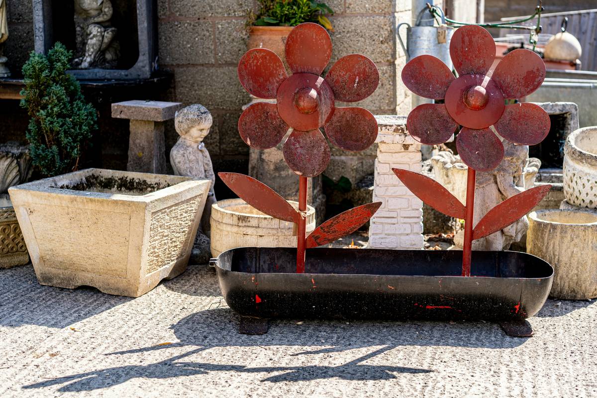 unique ideas for outdoor planters featuring repurposed gutters and stacked ceramic bowls arranged vertically on a patio wall